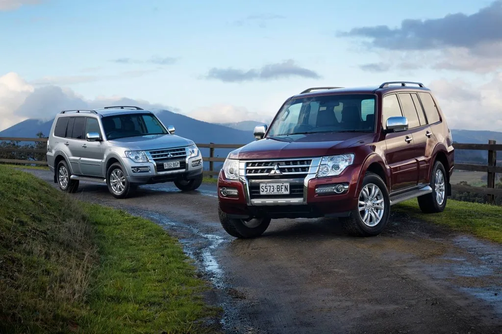 Red and silver 2016 Mitsubishi Pajero models parked on a rural road