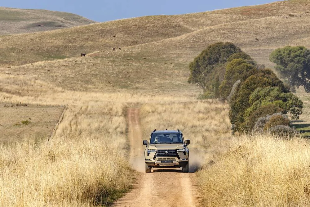 Lexus GX Overtrail on country dirt road Pre-production model shown. Final range and specifications may differ from those depicted.