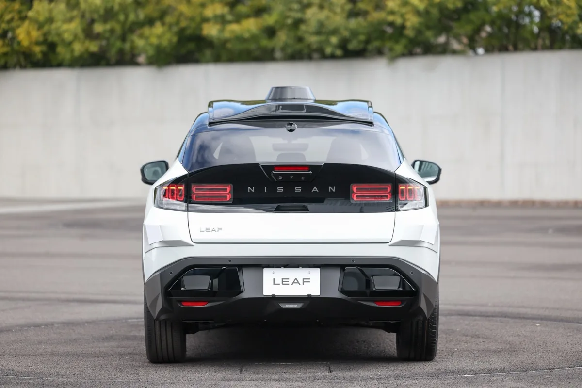 Nissan LEAF robotaxi rear view with illuminated full-width tail light bar and NISSAN lettering