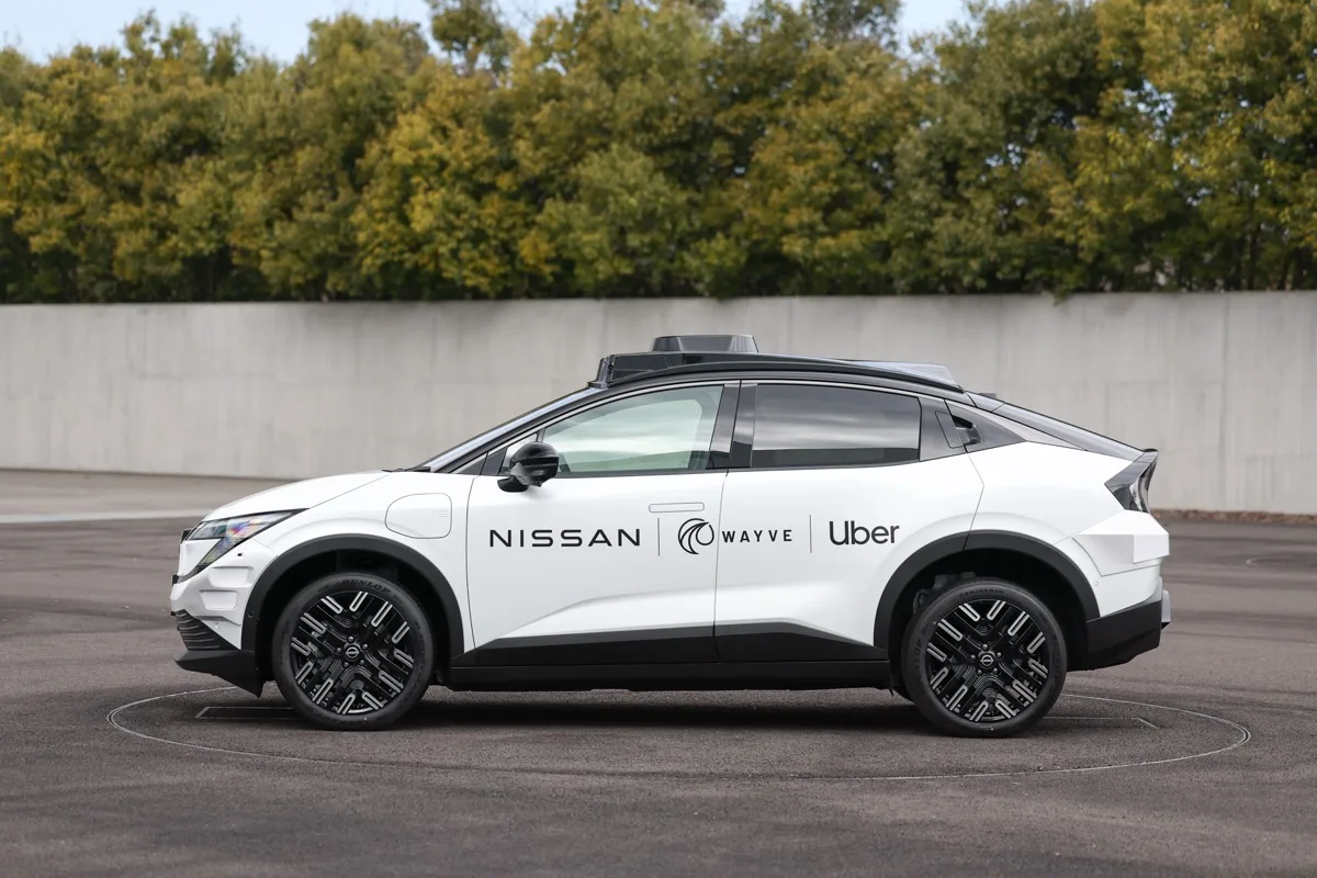 Nissan LEAF robotaxi side profile showing Nissan Wayve Uber door branding