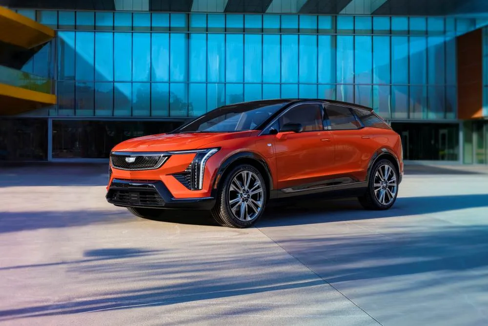 A front 3/4 view of the 2025 Cadillac OPTIQ in Monarch Orange.