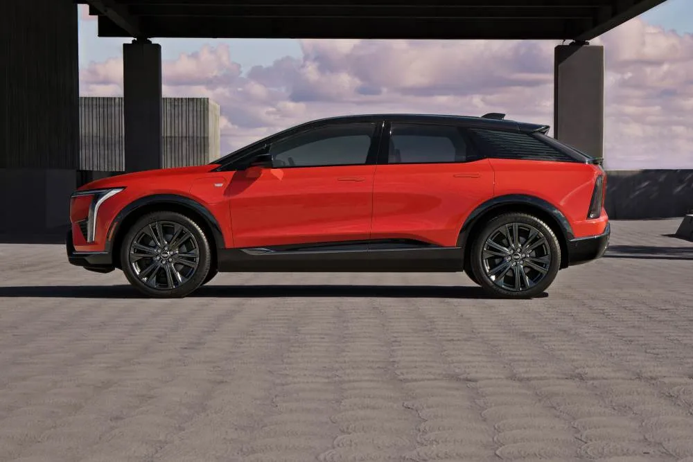 Side profile view of 2025 Cadillac OPTIQ in Monarch Orange.