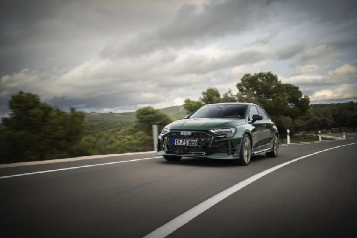 2026 Audi RS 3 competition limited sedan in Malachite green, rolling front three-quarter view on open road