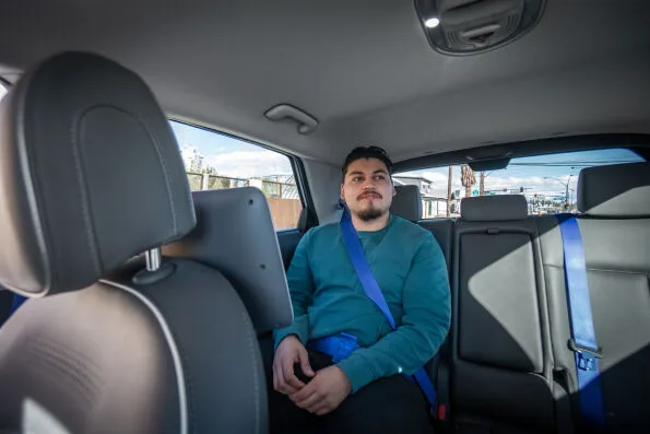 Passenger seated in rear of Motional IONIQ 5 robotaxi with empty driver seat