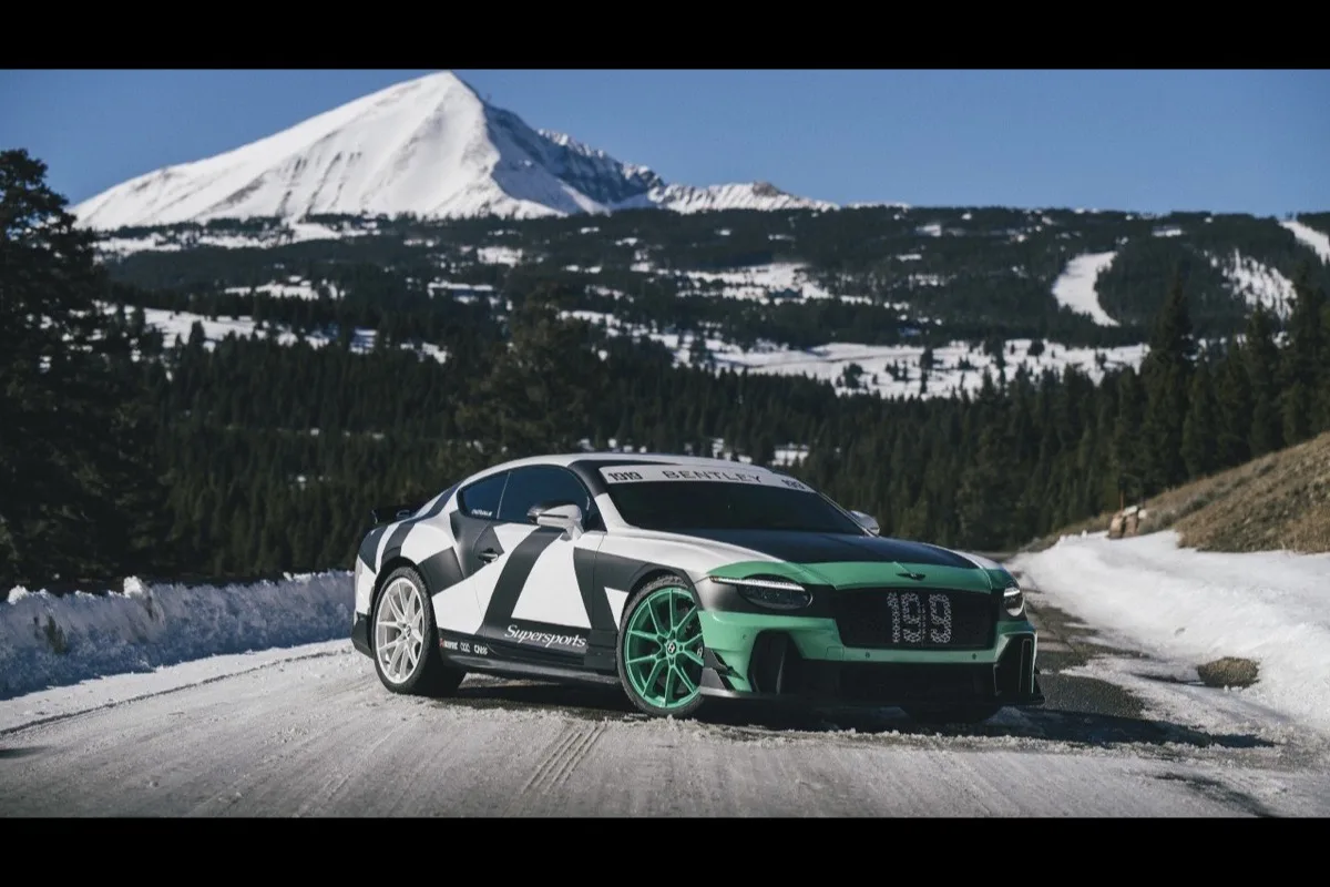 Bentley Supersports in green black and white livery parked on mountain road with snow-capped peaks behind