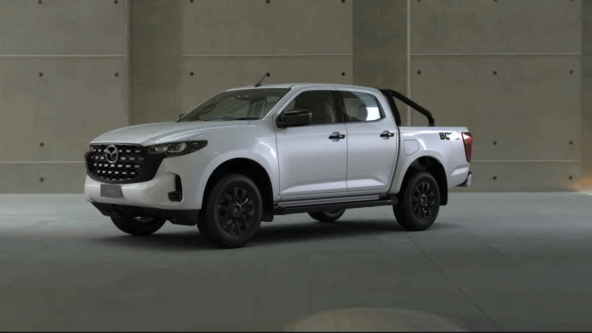 2026 Mazda BT-50 Boss dual cab ute front three-quarter view in Ice White with black sports bar and Boss decals