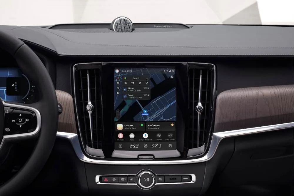 Vertical Volvo infotainment touchscreen showing navigation, media, phone widgets and climate controls in a premium dashboard.
