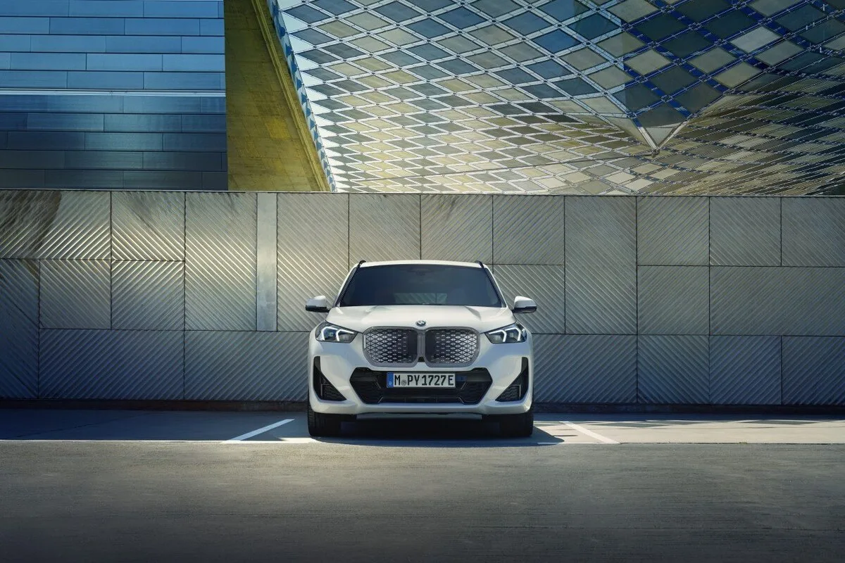2026 BMW iX1 front view in Alpine White architectural setting