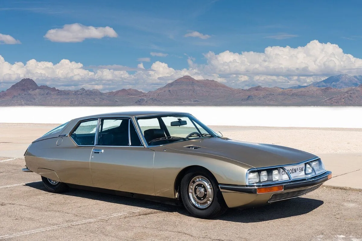 1975 Citroën SM in bronze at Bonneville Salt Flats with mountains behind