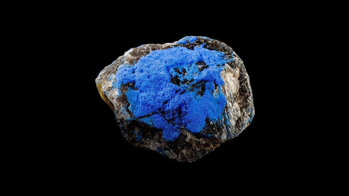 Blue cobalt mineral specimen on black background representing recycled battery materials