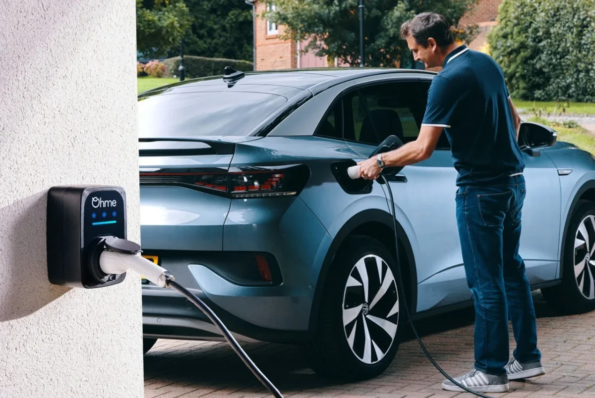 Man plugging charging cable into VW ID.4 with Ohme wall charger