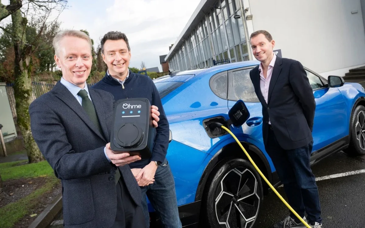 Three men in business attire with Ohme charger and blue Ford Puma Gen-E