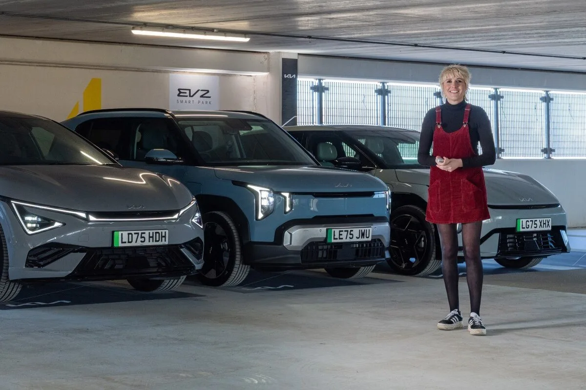 Maisie Adam standing with three Kia EV2 models at EV2 Smart Park Southampton