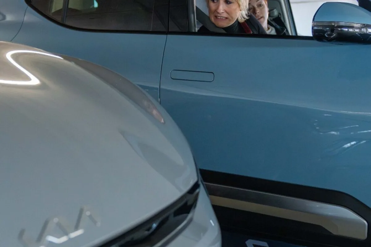 Comedian Maisie Adam looking worried while parking blue Kia EV2 in tight space