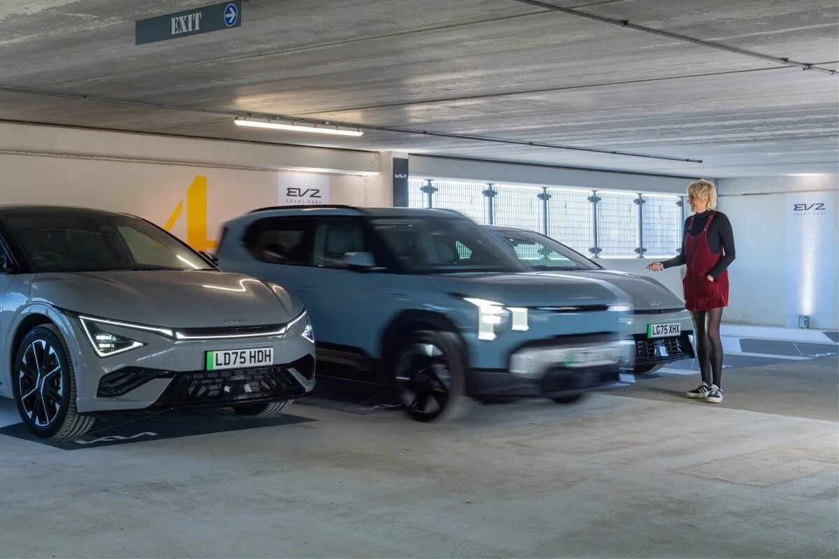 Maisie Adam standing outside Kia EV2 using remote parking from key fob