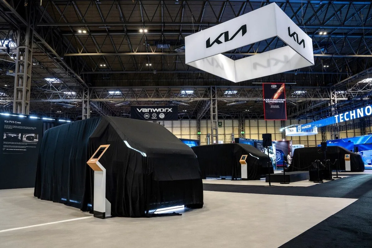 Kia PV5 vehicles under black covers at CV Show 2025