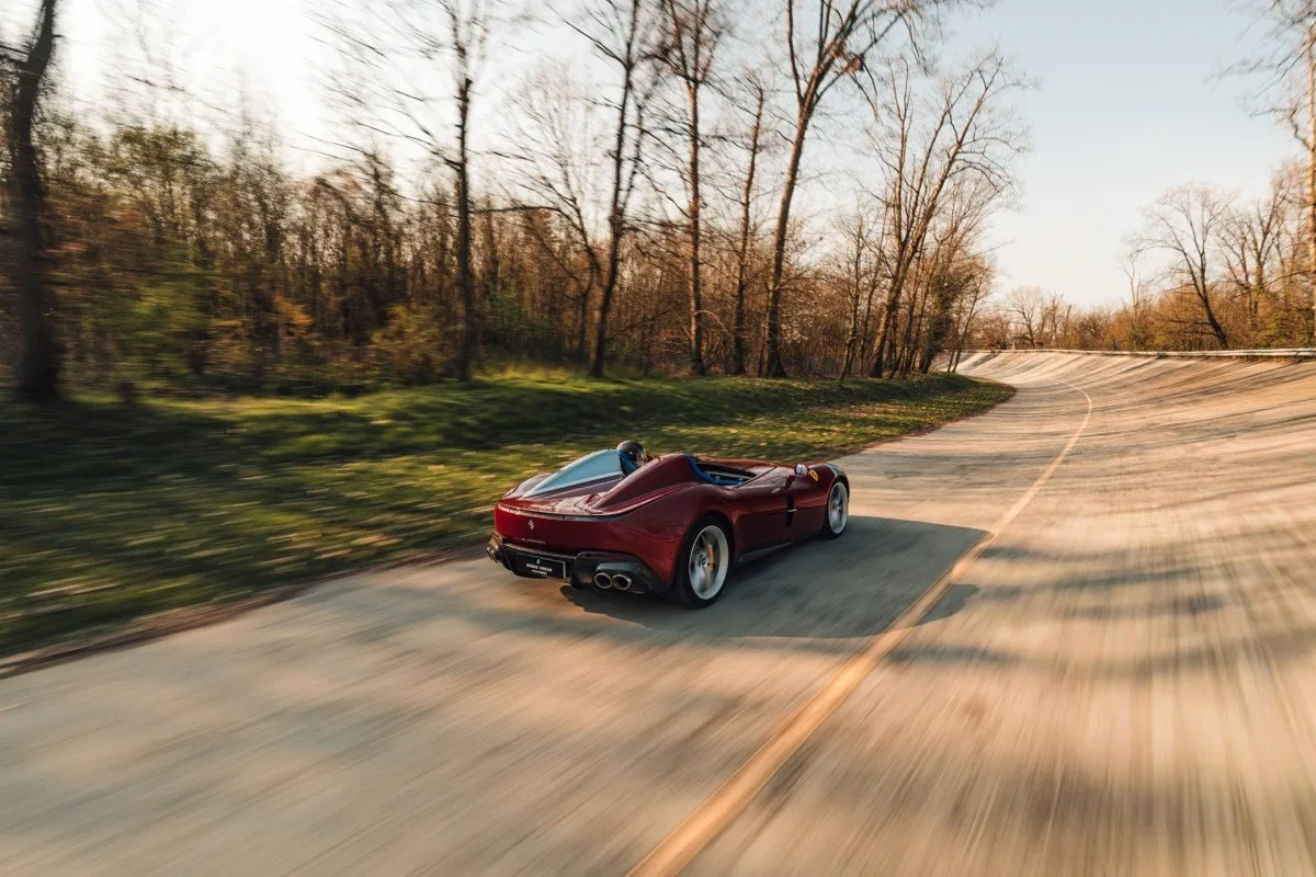 Ferrari Monza SP2 in motion showing rear three-quarter view with motion blur on road