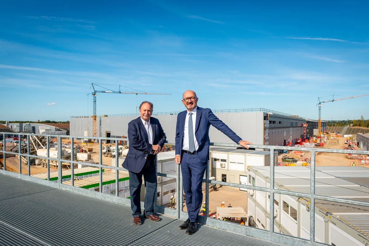 Two executives overlooking Rolls-Royce Goodwood extension construction site with cranes