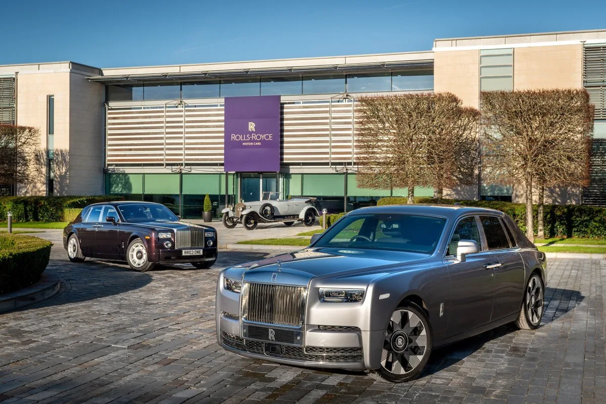 Rolls-Royce Phantom models spanning generations outside Goodwood headquarters with vintage Silver Ghost