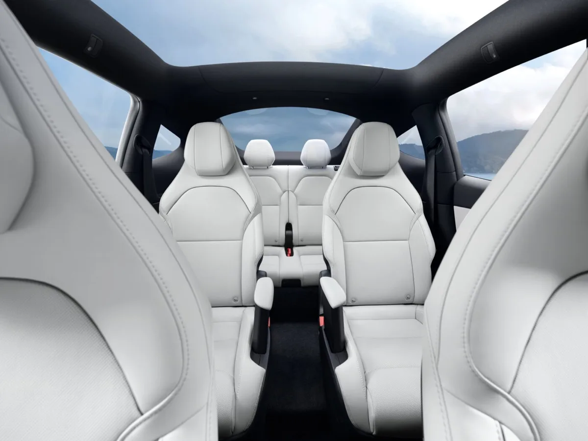 Tesla Model Y L interior view from cargo area showing three rows of white seats and glass roof