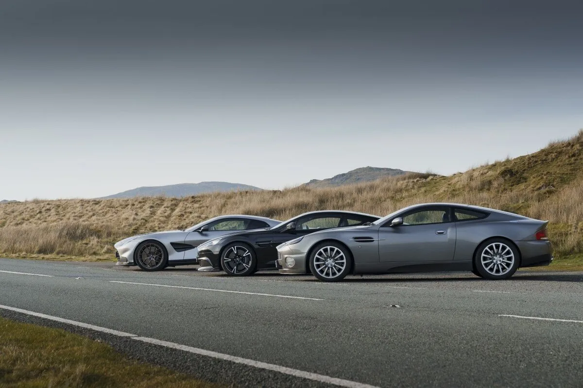 Three Aston Martin Vanquish models side by side on a Welsh mountain road