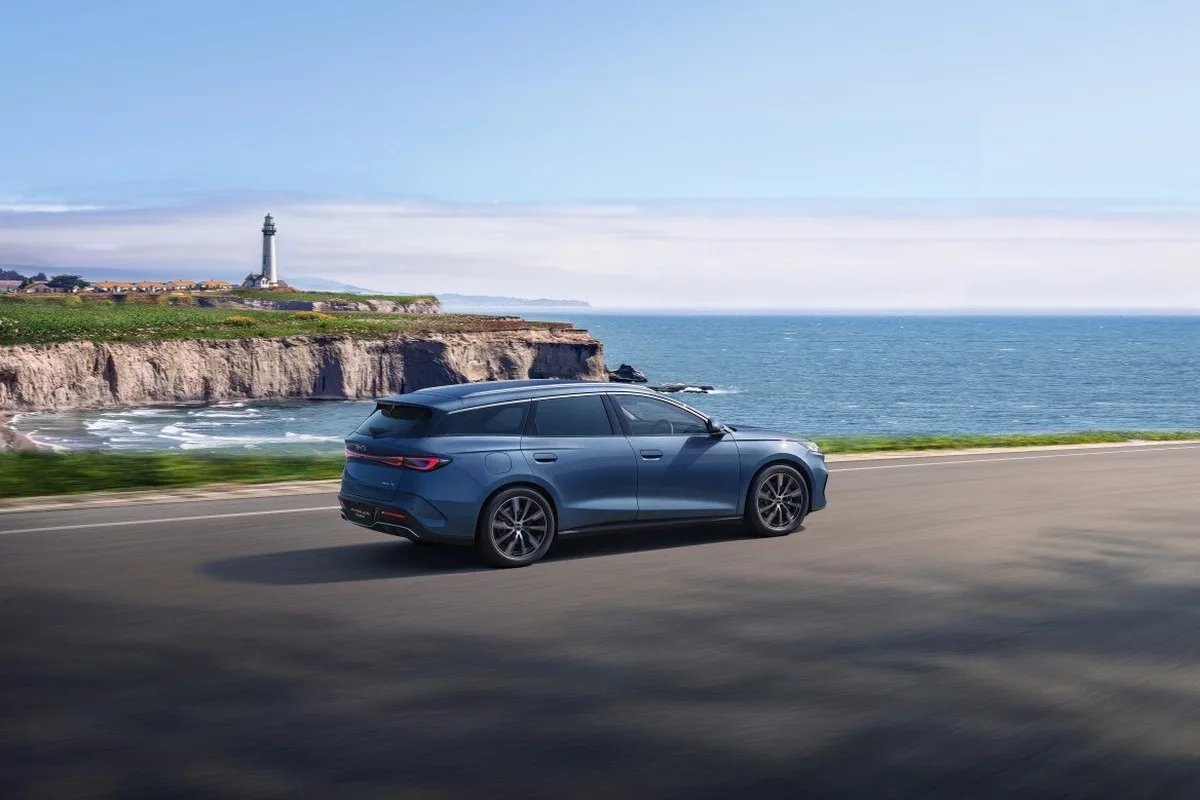 2026 BYD Seal 6 Touring driving along a coastal road in blue