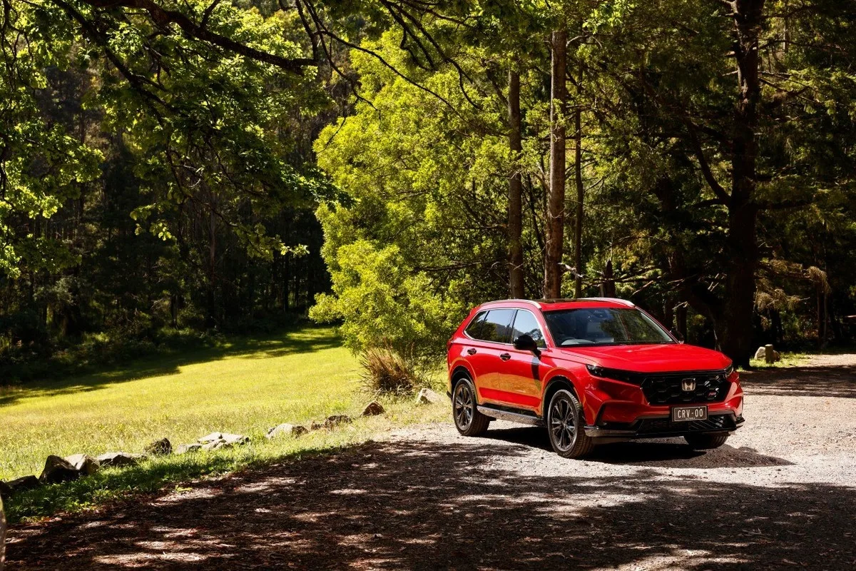 2026 Honda CR-V RS front three-quarter view in red on a forest road in Australia