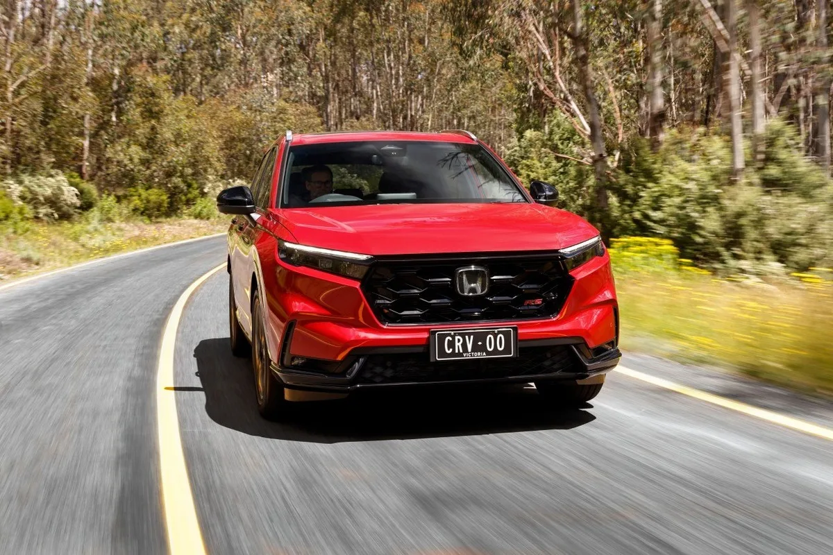 2026 Honda CR-V RS front driving shot in red on a winding country road