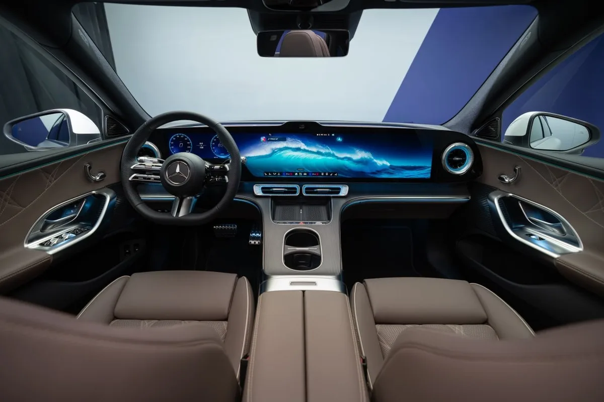 Front cabin of the Mercedes-Benz electric C-Class showing the wide digital screen and ambient-lit dashboard.