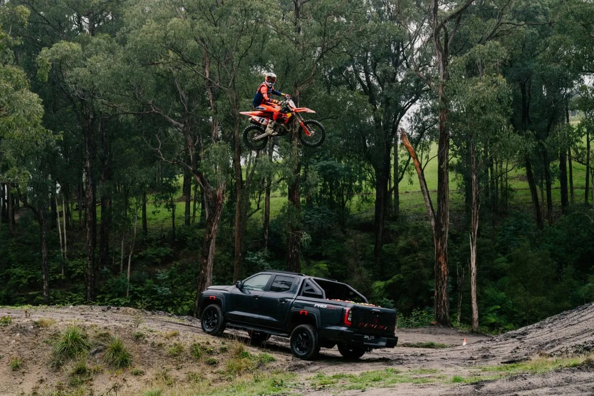 Nissan Navara PRO-4X on an off-road track with Daniel Sanders airborne on a dirt bike