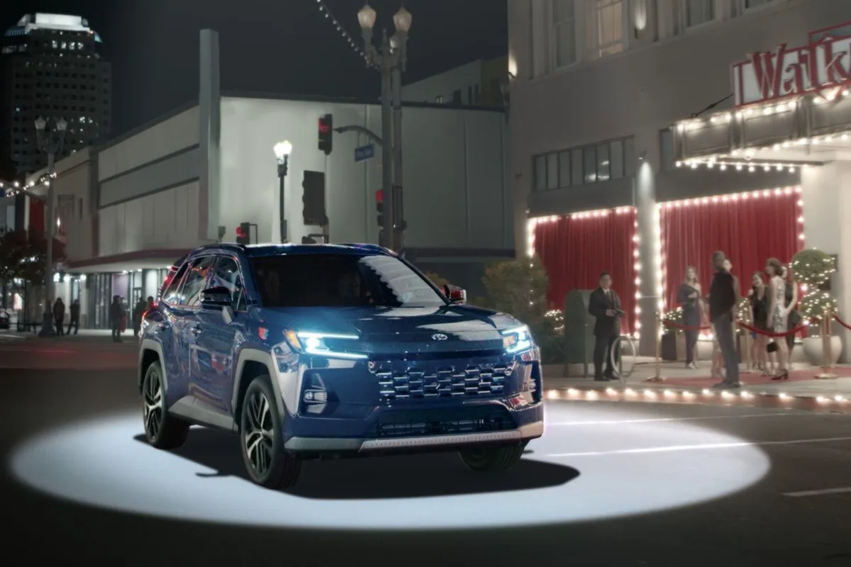 2026 Toyota RAV4 blue SUV in nighttime city scene for US campaign