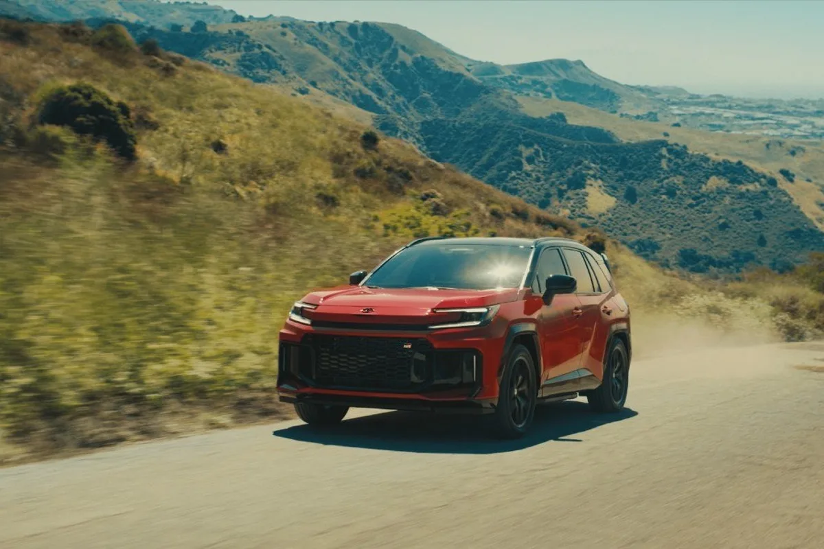 2026 Toyota RAV4 red SUV driving on mountain road in US campaign image