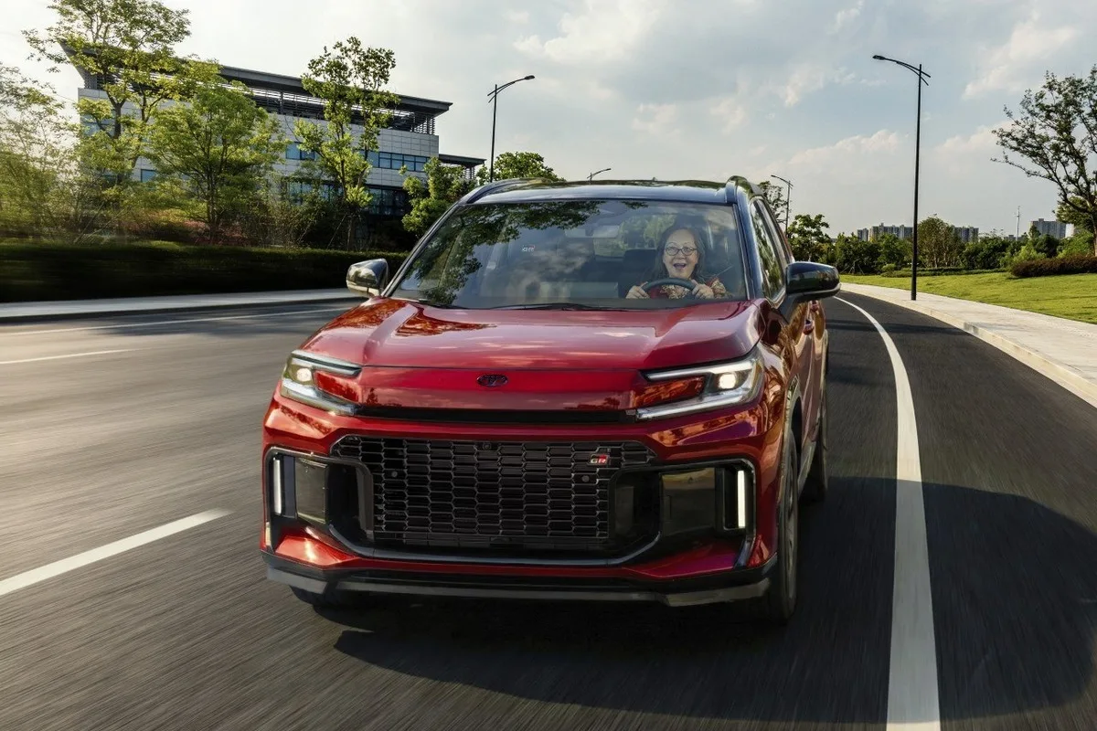 2026 Toyota RAV4 red front view driving in urban setting for US ad campaign