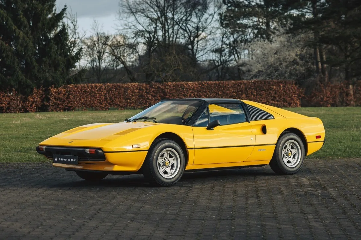 Yellow Ferrari 308 GTS on paved estate grounds