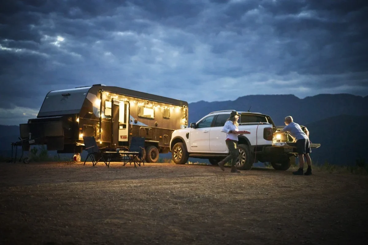 Ford Ranger with caravan at dusk, fairy lights in campsite