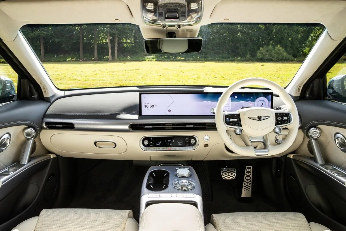 Front interior view of a right hand drive Genesis GV60 with dual screen dashboard