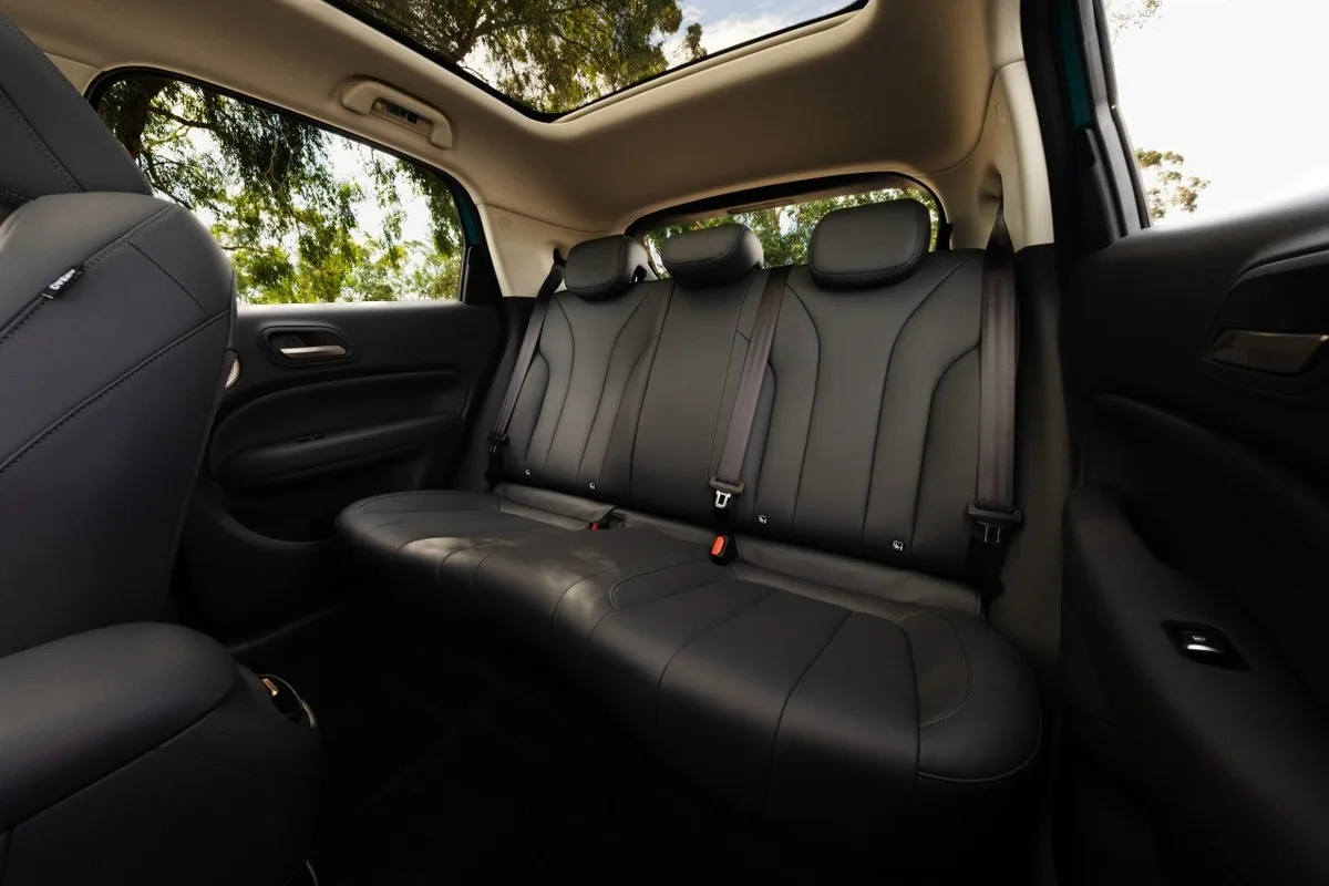 2026 GWM ORA 5 rear seat cabin with black upholstery, three headrests, and panoramic glass roof