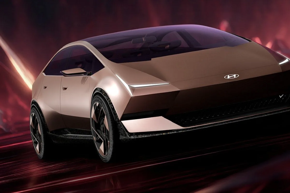 Low angle front three quarter studio view of the Hyundai VENUS concept in bronze with slim LED lights and black roof