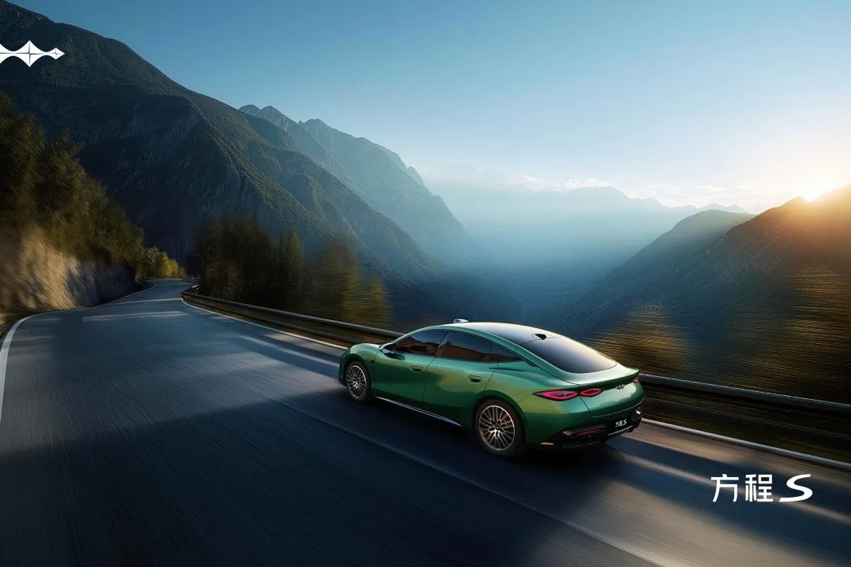 Fangchengbao FORMULA S green sedan driving on a mountain road at sunrise