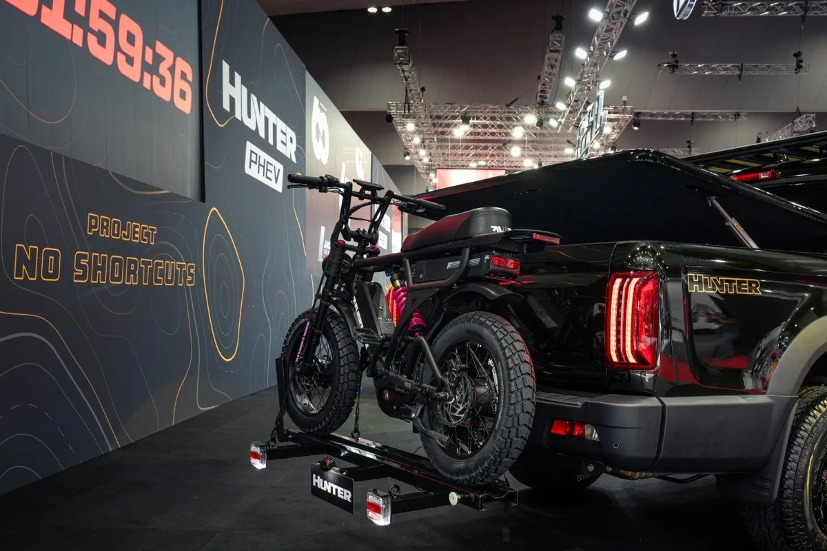 2026 JAC Hunter PHEV in black shown from the rear three quarter with a hitch mounted fat tyre bike rack
