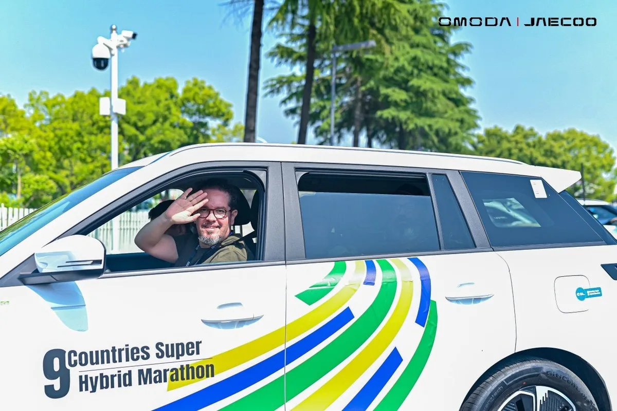 Driver waving from a Jaecoo SUV with 9 Countries Super Hybrid Marathon livery