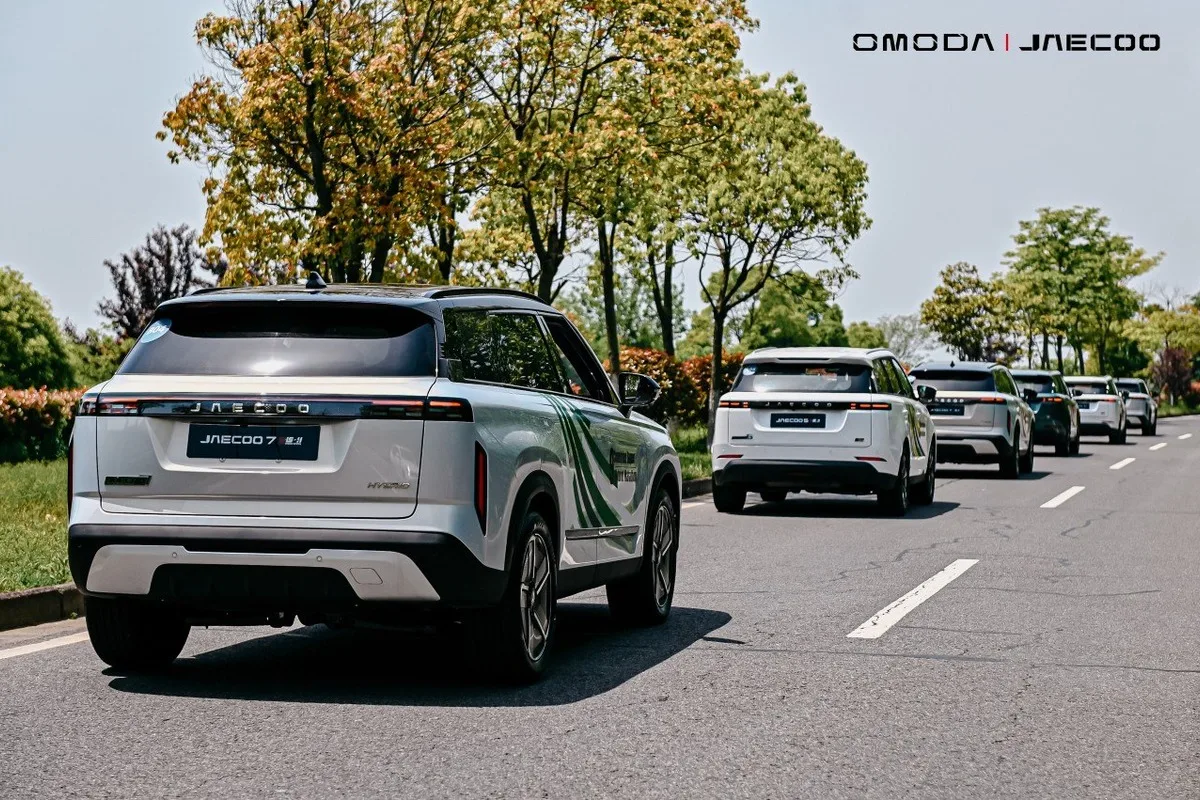 Rear view of Jaecoo SUVs travelling together on a tree-lined road during the hybrid endurance drive