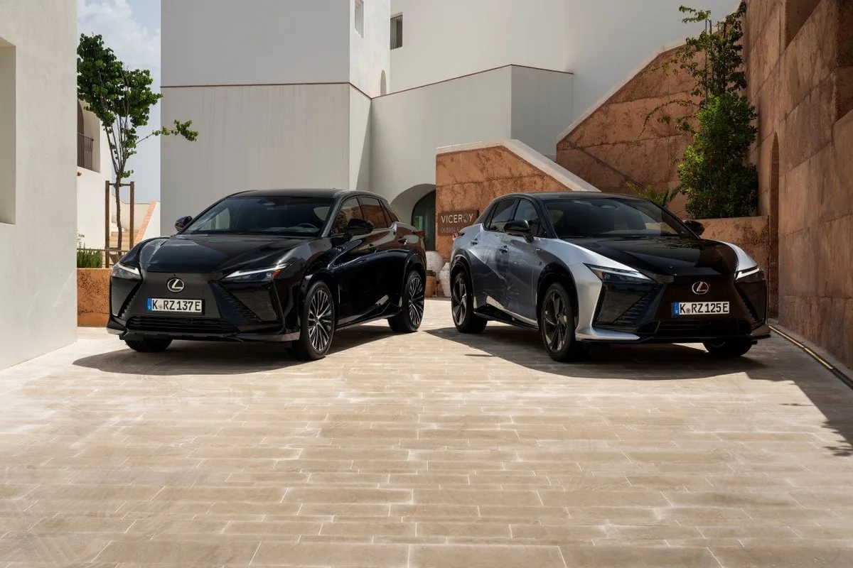 Two 2026 Lexus RZ electric SUVs parked in a sunlit courtyard
