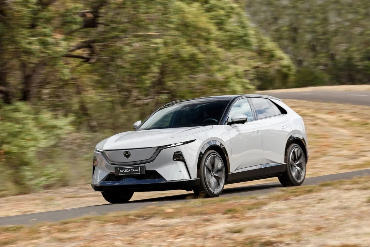 White Mazda CX-6e shown from the front three quarter angle on a winding road