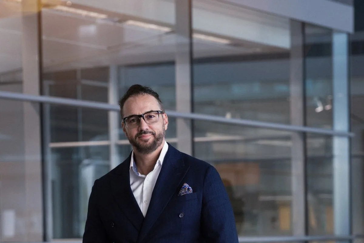 Kemal Curic standing with McLaren supercars in a showroom