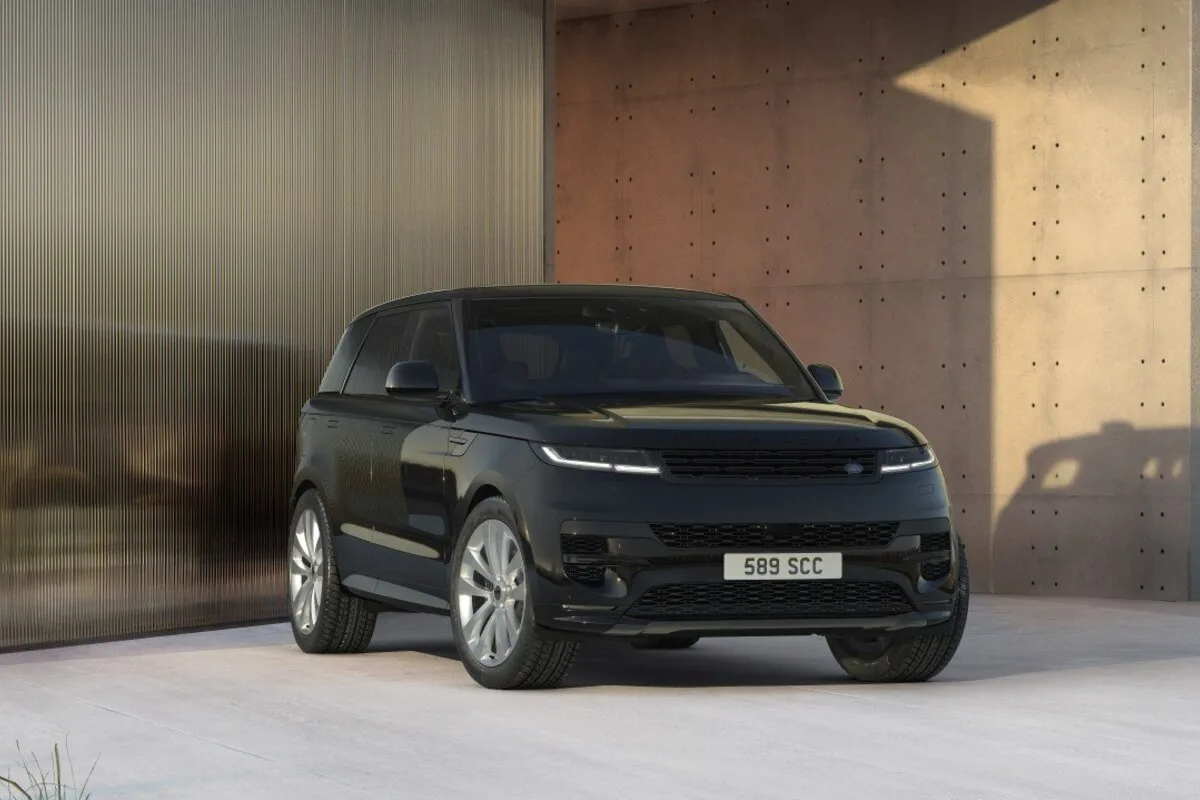 2026 Range Rover Sport TWENTY Edition in Santorini Black front three quarter view with silver wheels in modern architectural setting