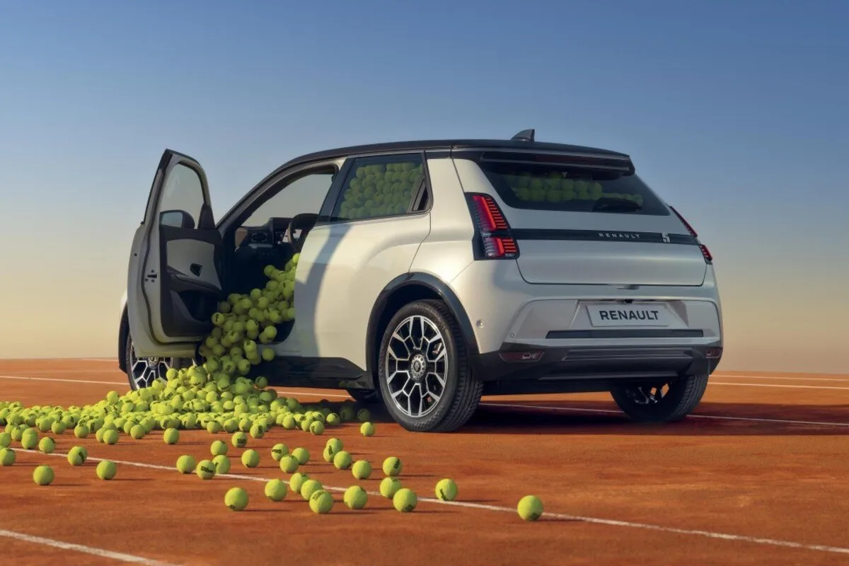 White Renault 4 Roland Garros show car with tennis balls spilling onto a clay court