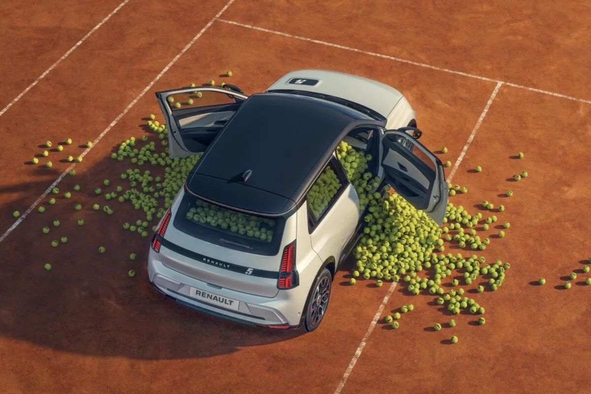 Renault 5 on a clay tennis court with tennis balls spilling from the cabin