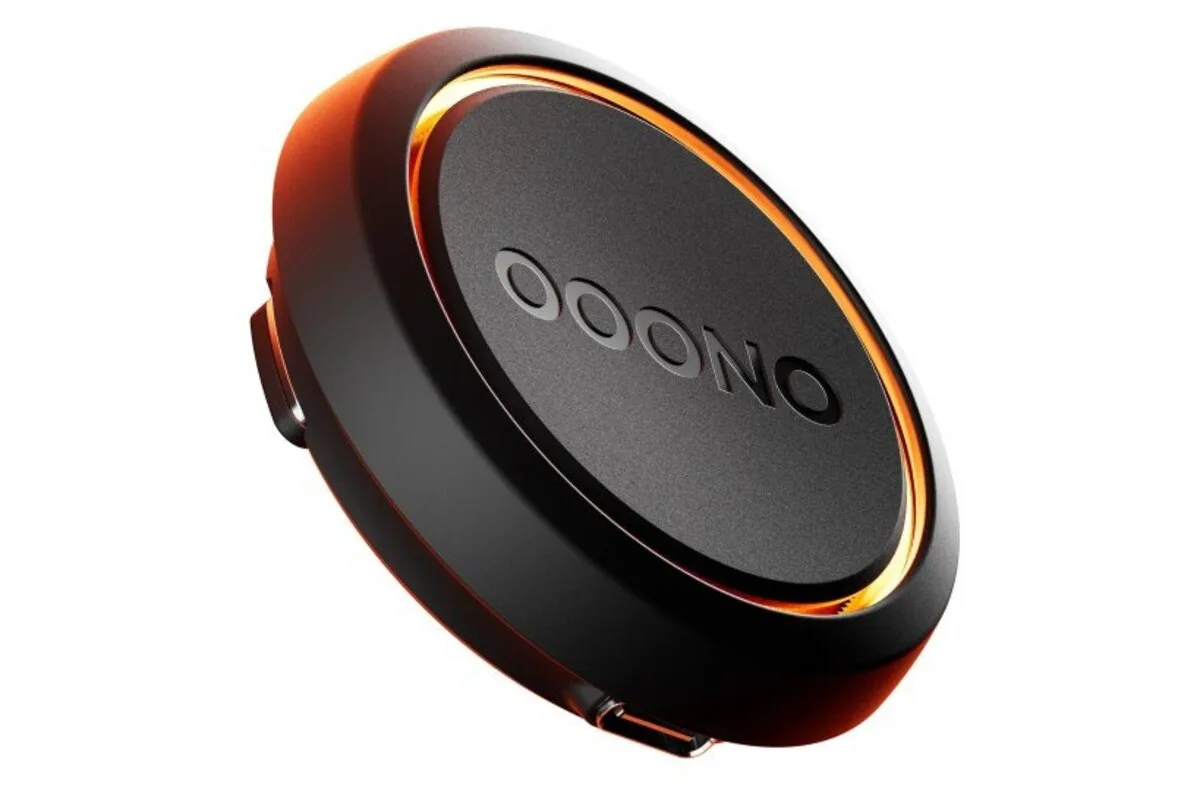 Black OOONO CO-DRIVER device with an orange illuminated ring on a white background