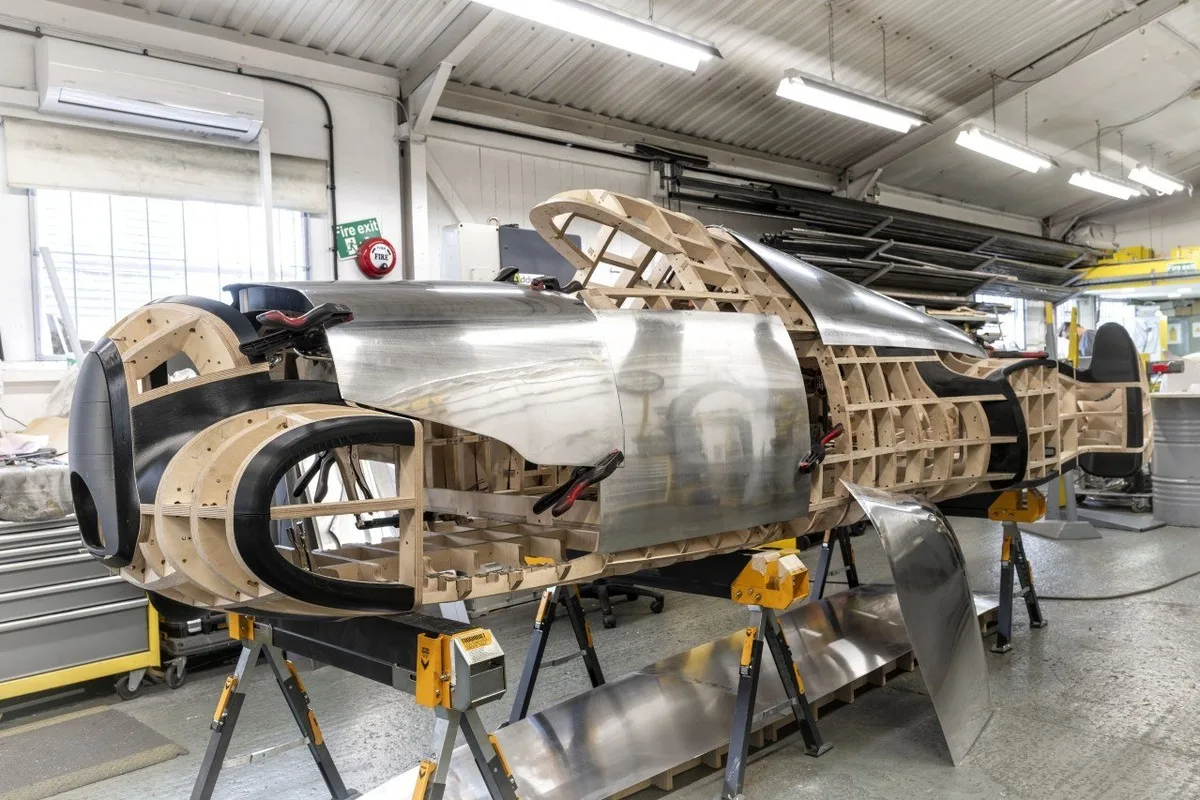 Metal panels being fitted to the wooden frame during Auto Union Type 52 fabrication.